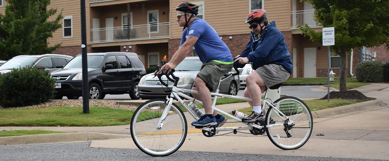 Two people riding a tandem bike.